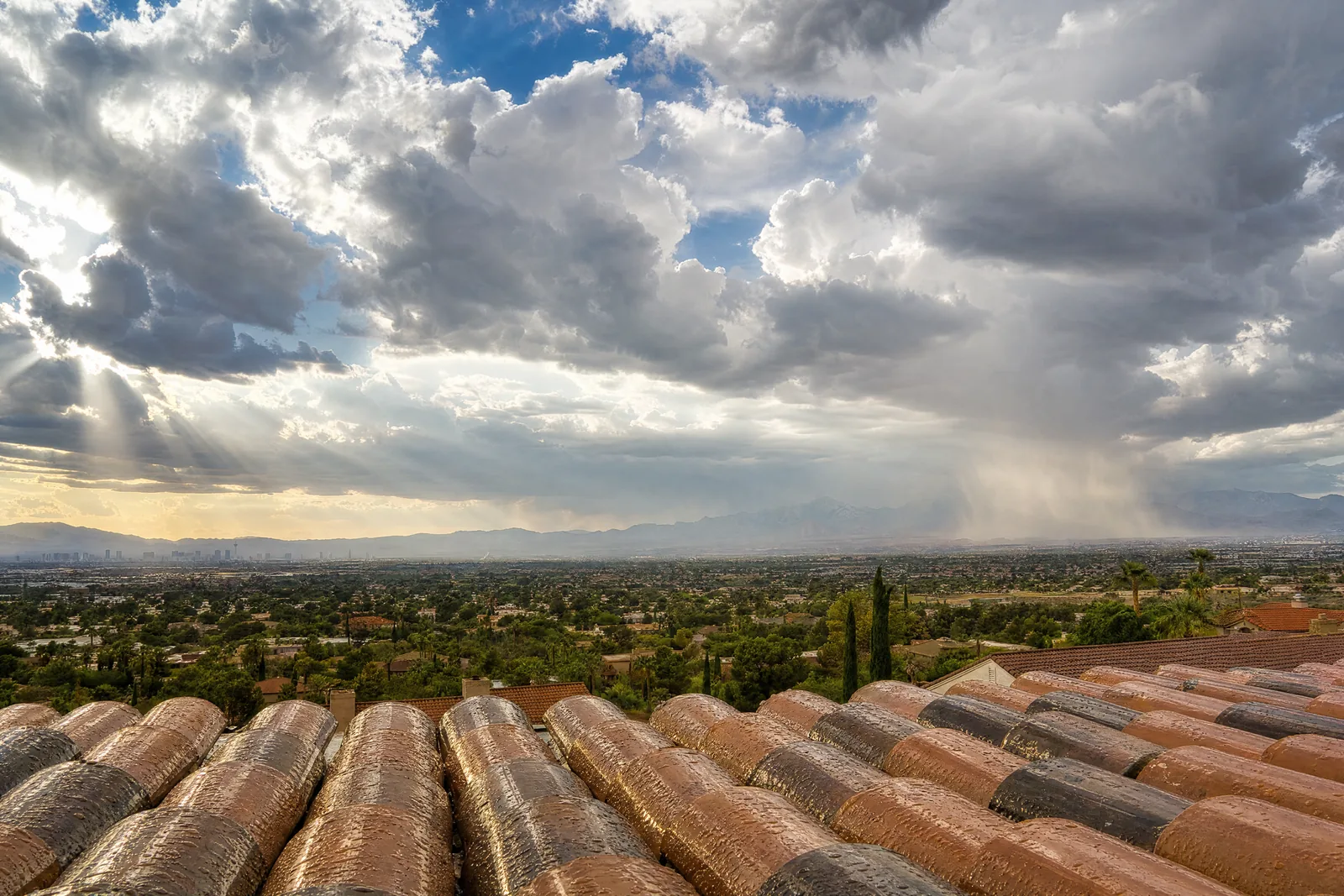 Monsoon storm clouds and lightning over a Las Vegas neighbourhood of tile roofs